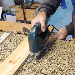 In this photo, a WARCO flooring tile in puzzle form is being cut with a jigsaw. The flexible material can be worked easily with standard tools, allowing for custom fitting. This way, the floor covering can be precisely adapted to edges, corners, and recesses. The sturdy and elastic surface remains intact, ensuring a long-lasting, low-maintenance solution.