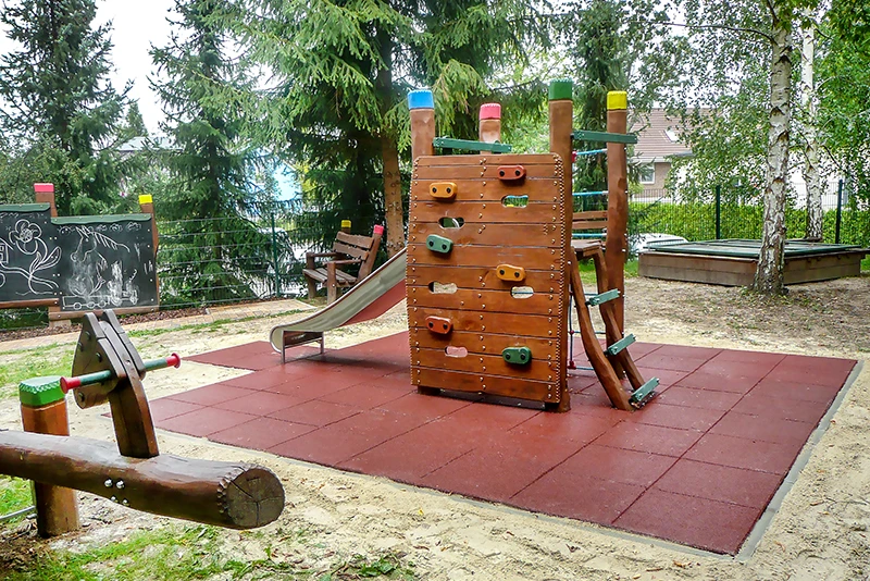 Near-natural playground with fall protection slabs The maintenance-free, synthetic fall protection made of WARCO fall protection slabs is also a particularly advantageous and aesthetically pleasing solution for this natural playground. The red safety tiles provide long-lasting, maintenance-free fall protection around the climbing tower.