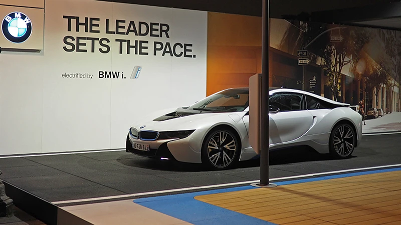 The I8 from BMW is presented at a trade fair. The super sports car stands on the black event floor from WARCO, which is modelled on the asphalt of a road.